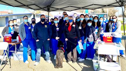Assemblymember Dr. Joaquin Arambula and Kathleen “Kathi” Rindahl, a Fresno State assistant professor who leads the university’s nursing students (center, in red shirt), are seen with nursing students before a COVID-19 vaccination clinic begins at the Calwa Recreation and Park District on Feb. 18, 2021.