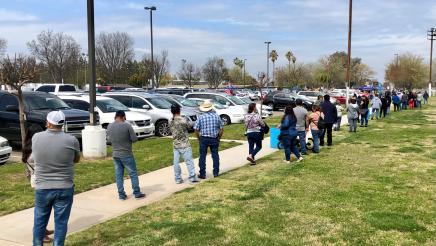 People wait in a long line for second doses of COVID-19 vaccinations at the Calwa Recreation and Park District on February 9, 2021. The clinic was one in a series that Assemblymember Dr. Joaquin Arambula and partners offered in 2021.