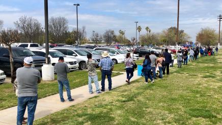 People wait in a long line for second doses of COVID-19 vaccinations at the Calwa Recreation and Park District on February 9, 2021. The clinic was one in a series that Assemblymember Dr. Joaquin Arambula and partners offered in 2021.