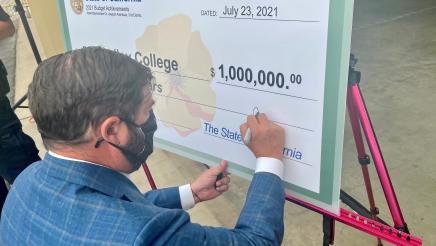 Assemblymember Dr. Joaquin Arambula signs the check representing the $1 million State allocation.