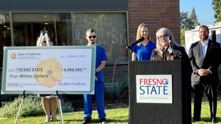 Kathleen “Kathi” Rindahl, speaking at the podium, is an assistant professor for the Fresno State College of Health and Human Services who oversees the Mobile Health Unit program.