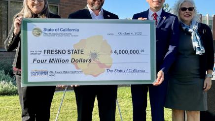 Assemblymember Dr. Joaquin Arambula shows the check for the $4 million State allocation with (from left) Kathleen “Kathi” Rindahl, an assistant professor who oversees the Mobile Health Unit; Fresno State President Dr. Saúl Jiménez-Sandoval; and Dr. Denise Seabert, Dean of the Fresno State College Health and Human Services.